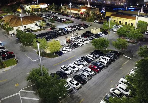 An aerial view of the outdoor LED lighting at The Palms Town 国家 building and parking lot at night